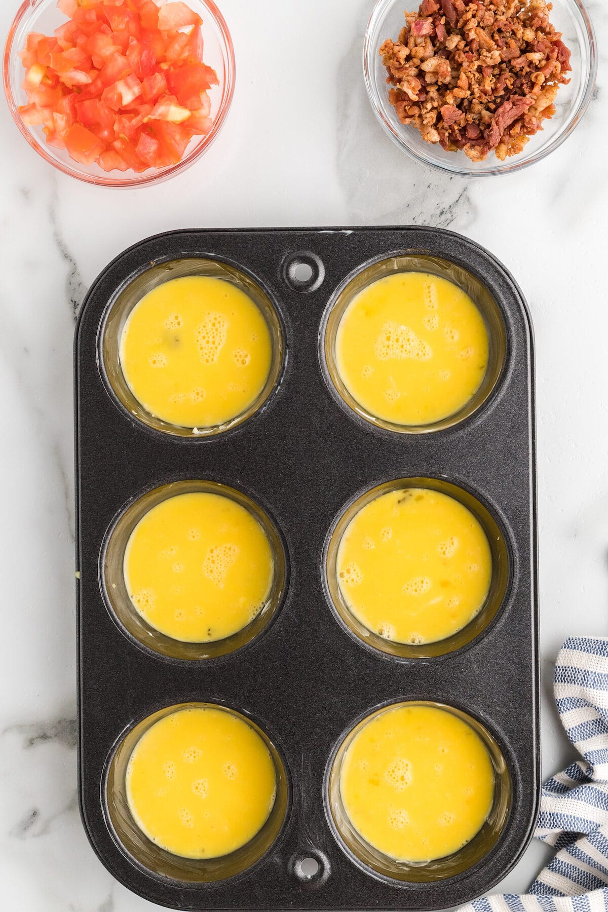 muffin tin filled with egg mixture. 