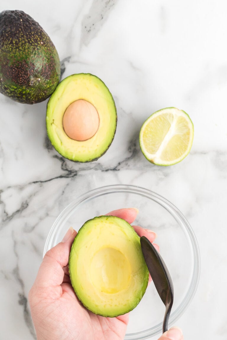 scooping avocado with a black spoon.