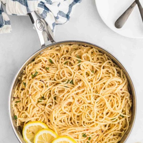 skillet with creamy lemon pasta and lemon slices to the side as garnish.