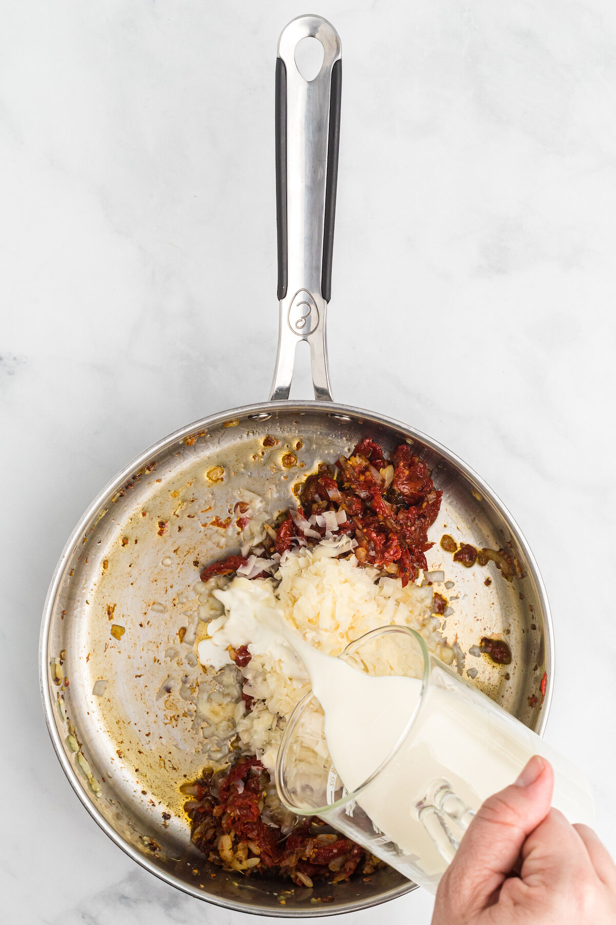 adding the heavy cream to the skillet mixture. 