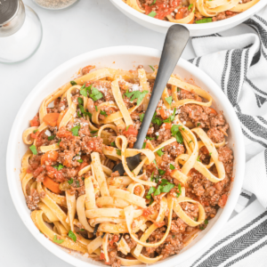 pasta with meat sauce in a white bowl.