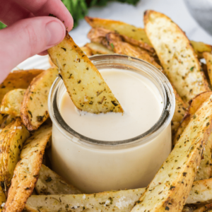air fryer potatoes with aioli sauce on a platter.
