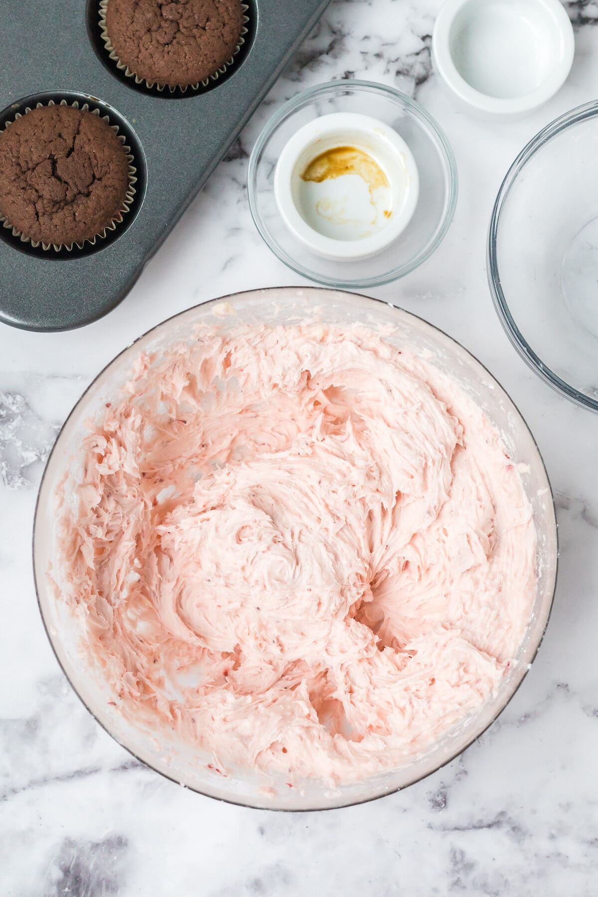 strawberry buttercream frosting in a glass bowl. 