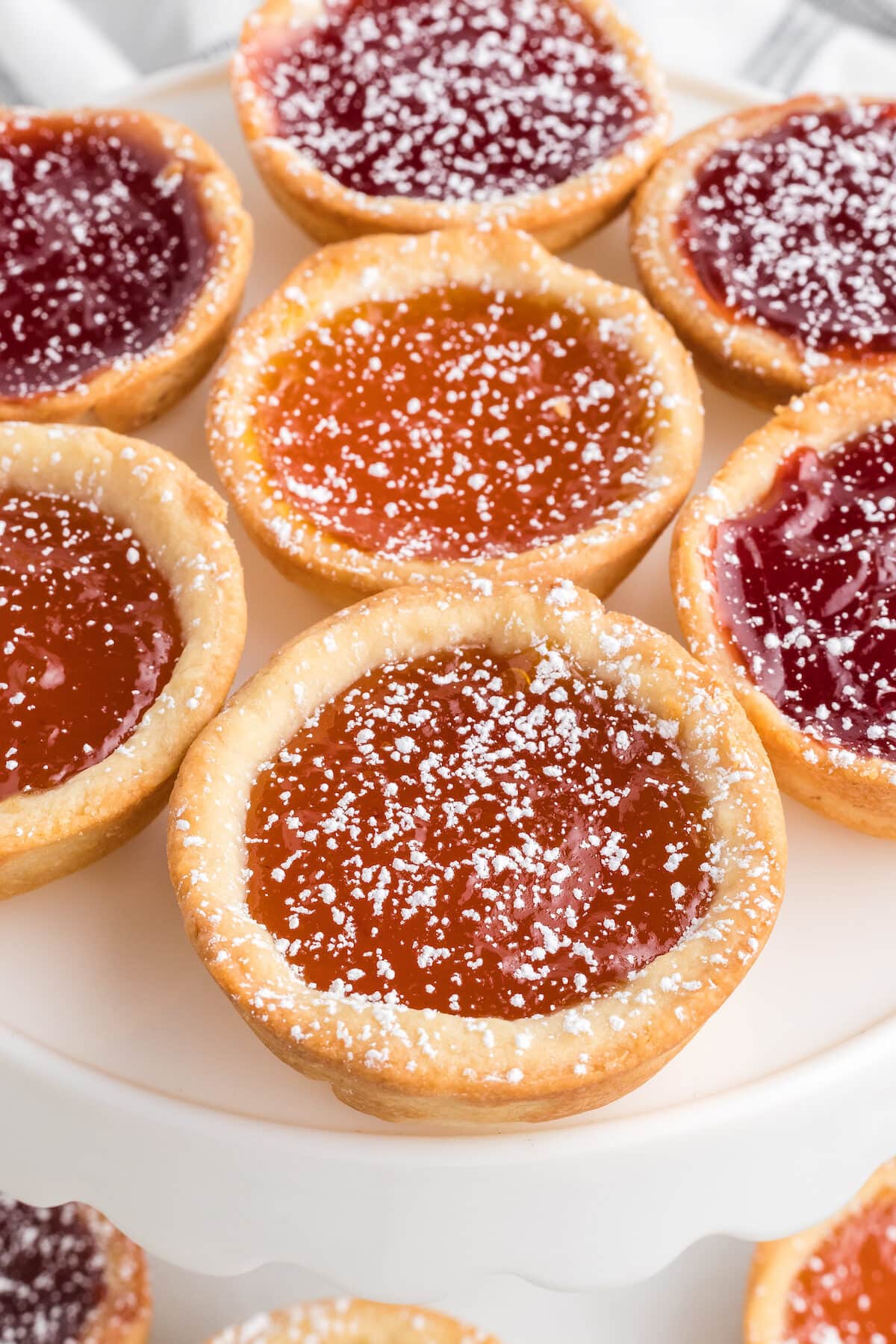 jam tarts displayed on a white cake stand. 
