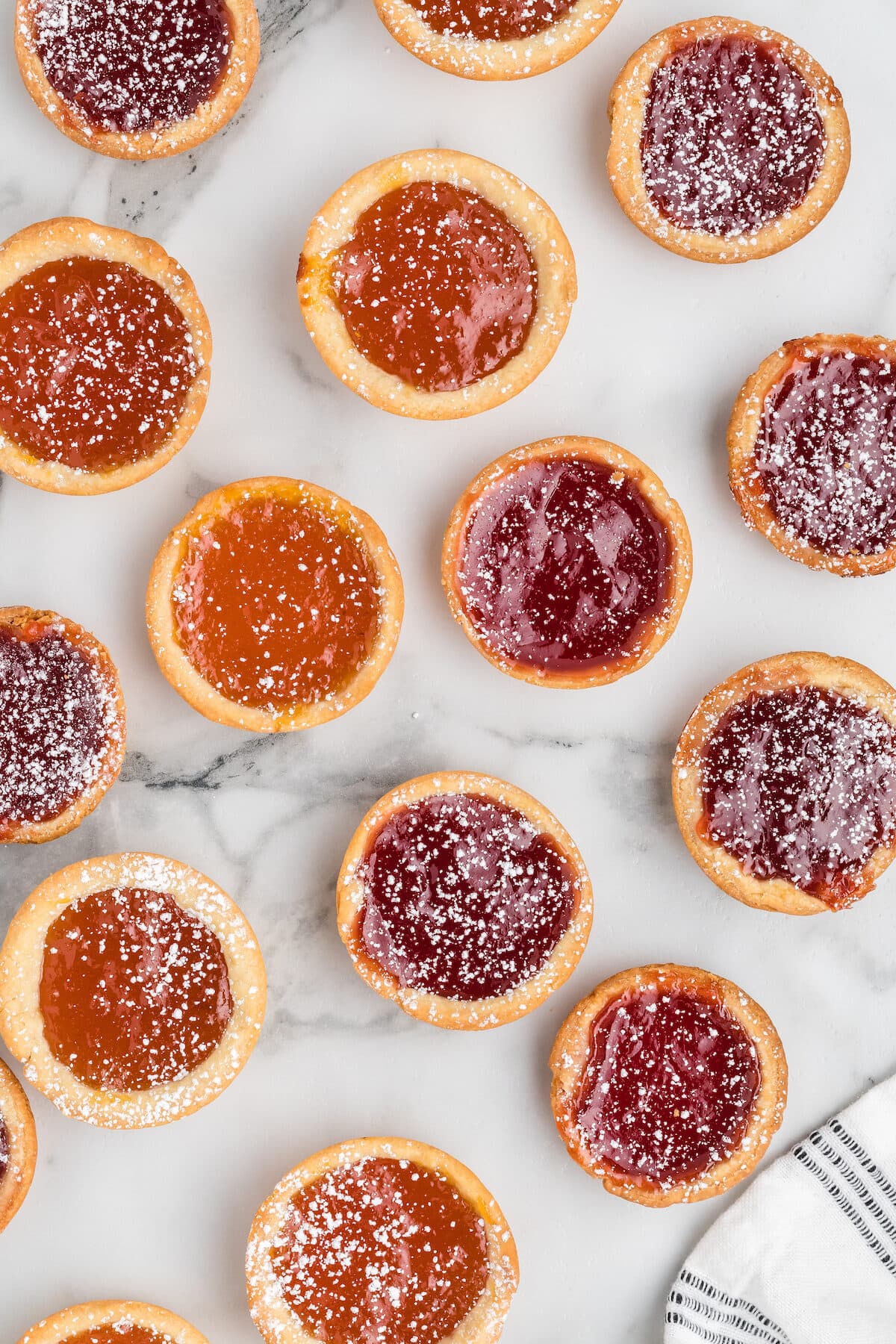 jam tarts lightly dusted with powdered sugar and on a countertop.