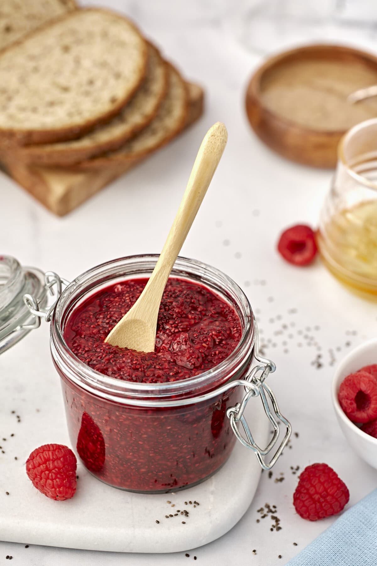 small weck storage jar filled with chia seed jam with a small wooden spoon inside.