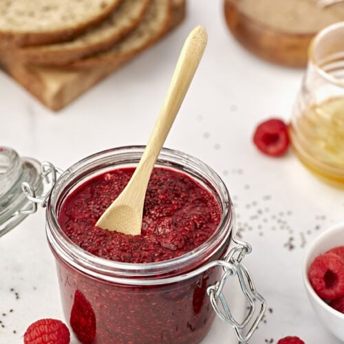 small weck storage jar filled with chia seed jam with a small wooden spoon inside.