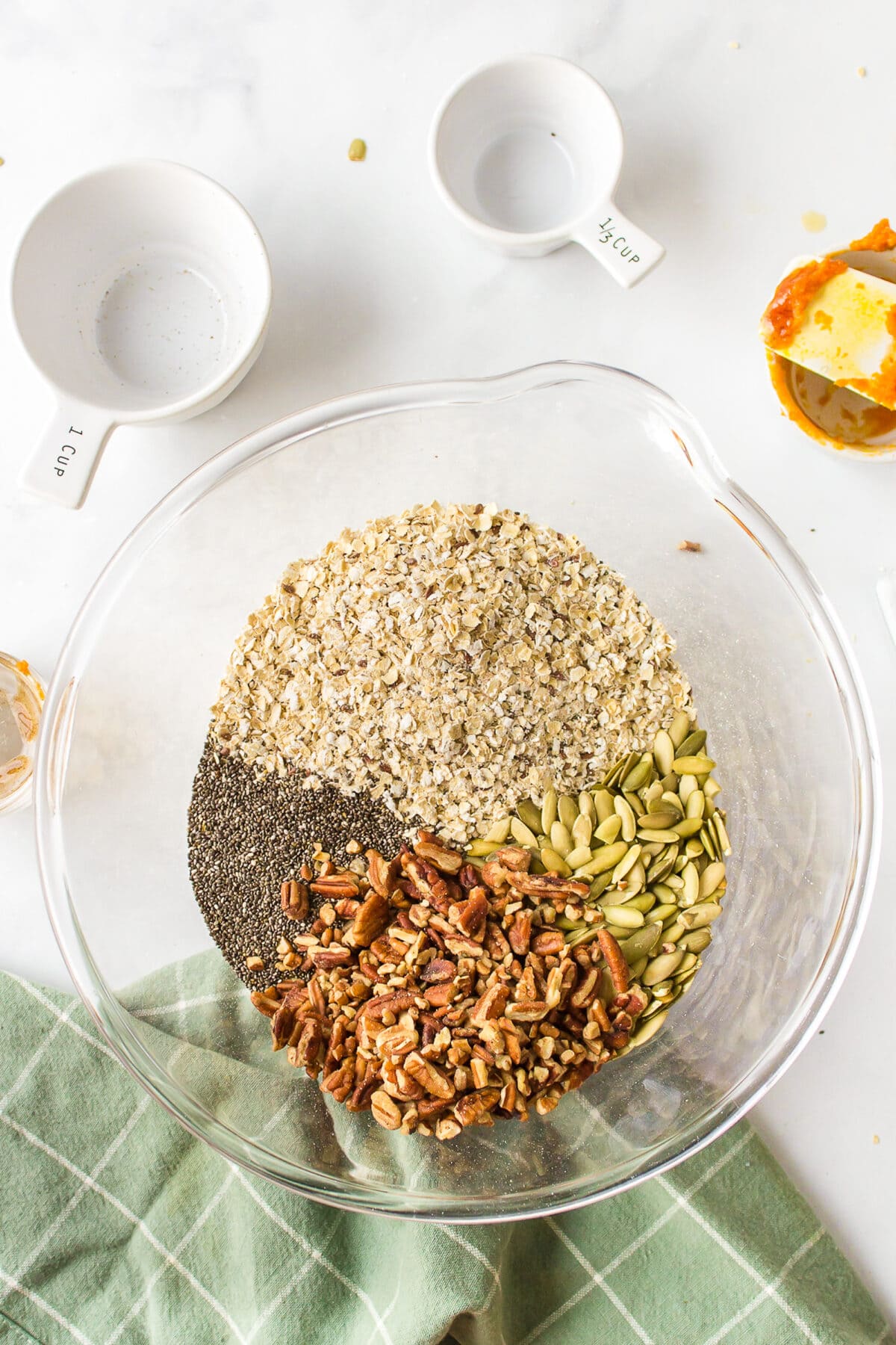 dry ingredients needed for the pumpkin maple granola recipe in a large glass mixing bowl. 