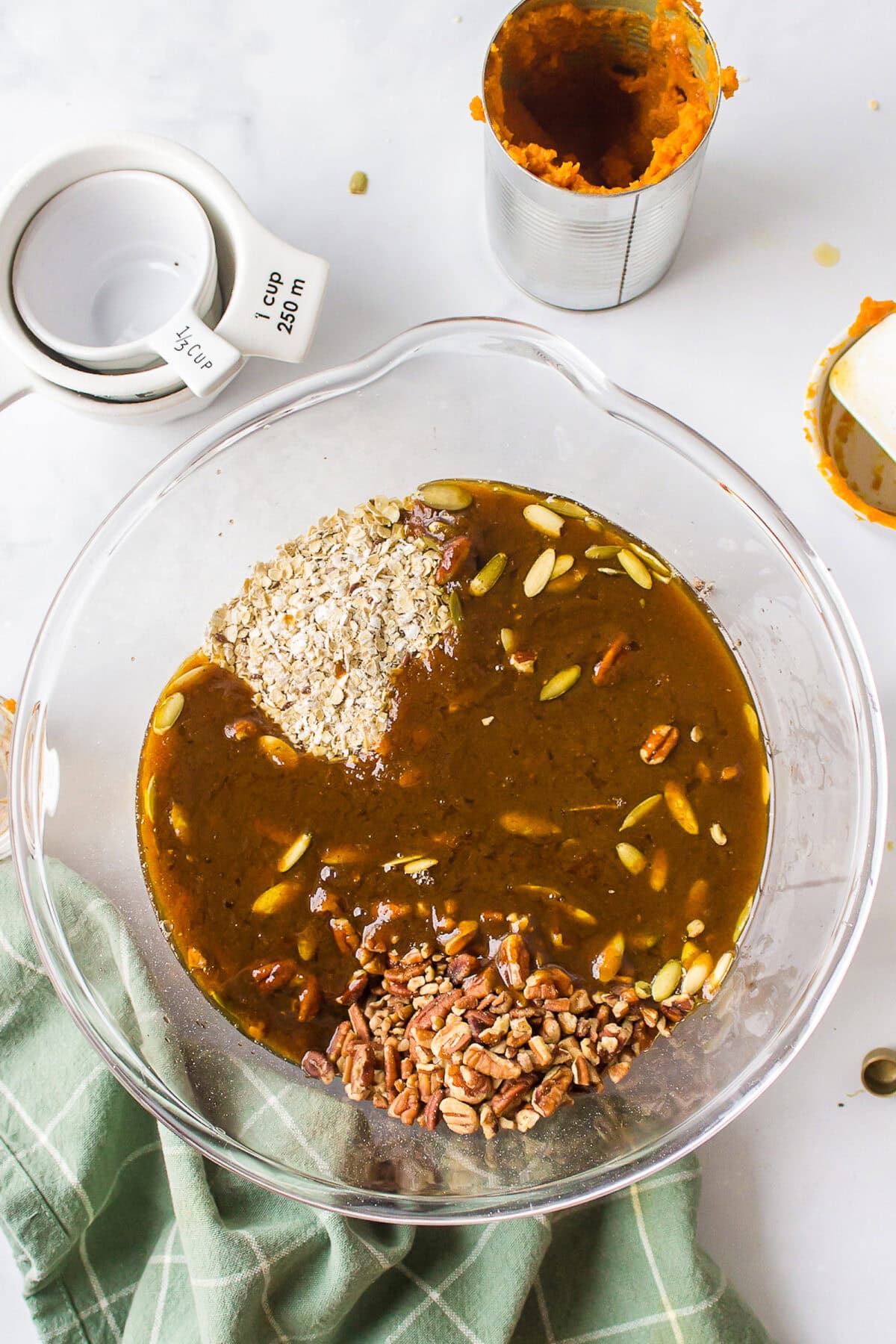 combining the dry ingredients with the wet ingredients for the pumpkin granola recipe in a large mixing bowl. 