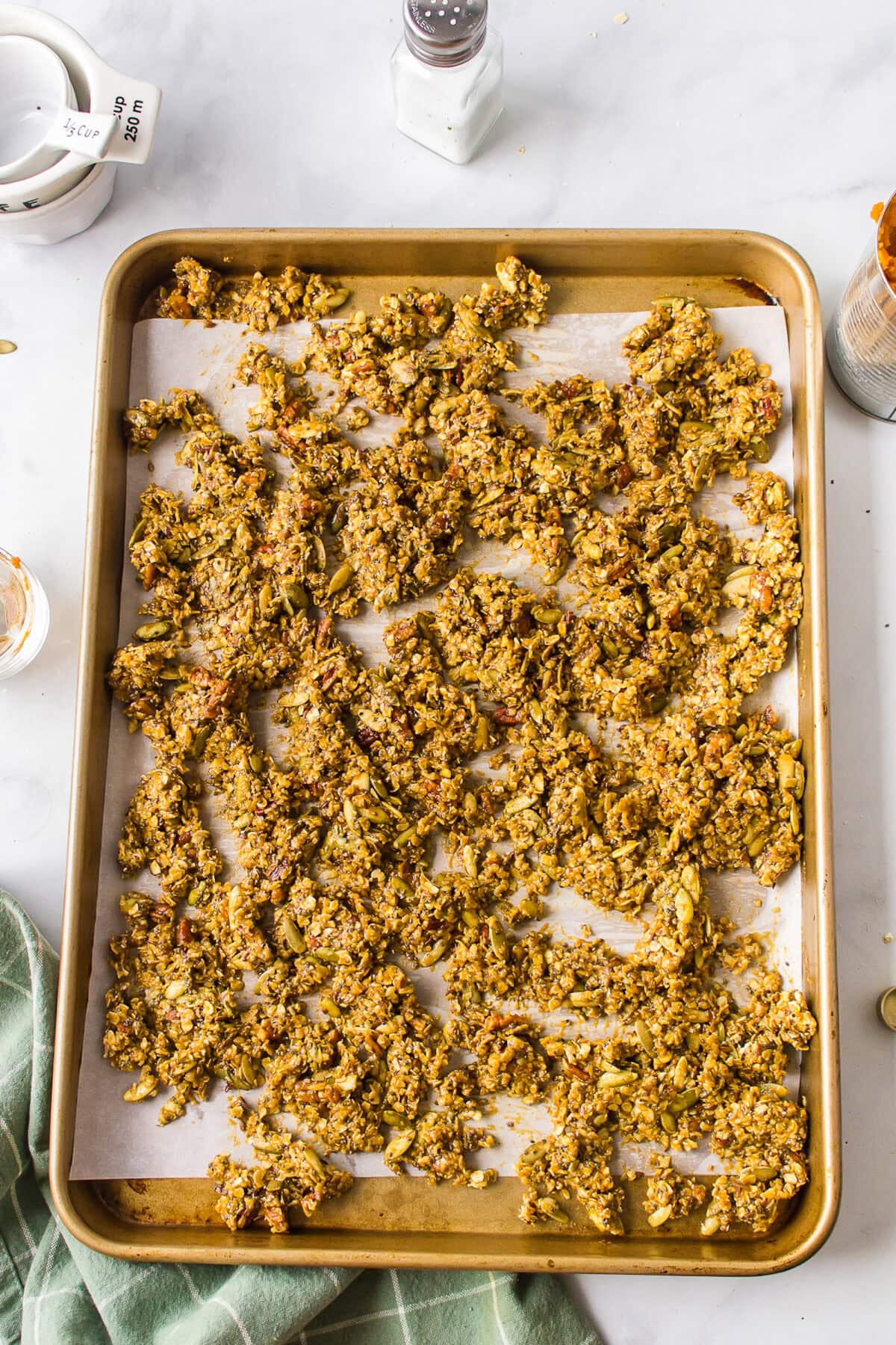 pumpkin granola spread over the baking sheet. 