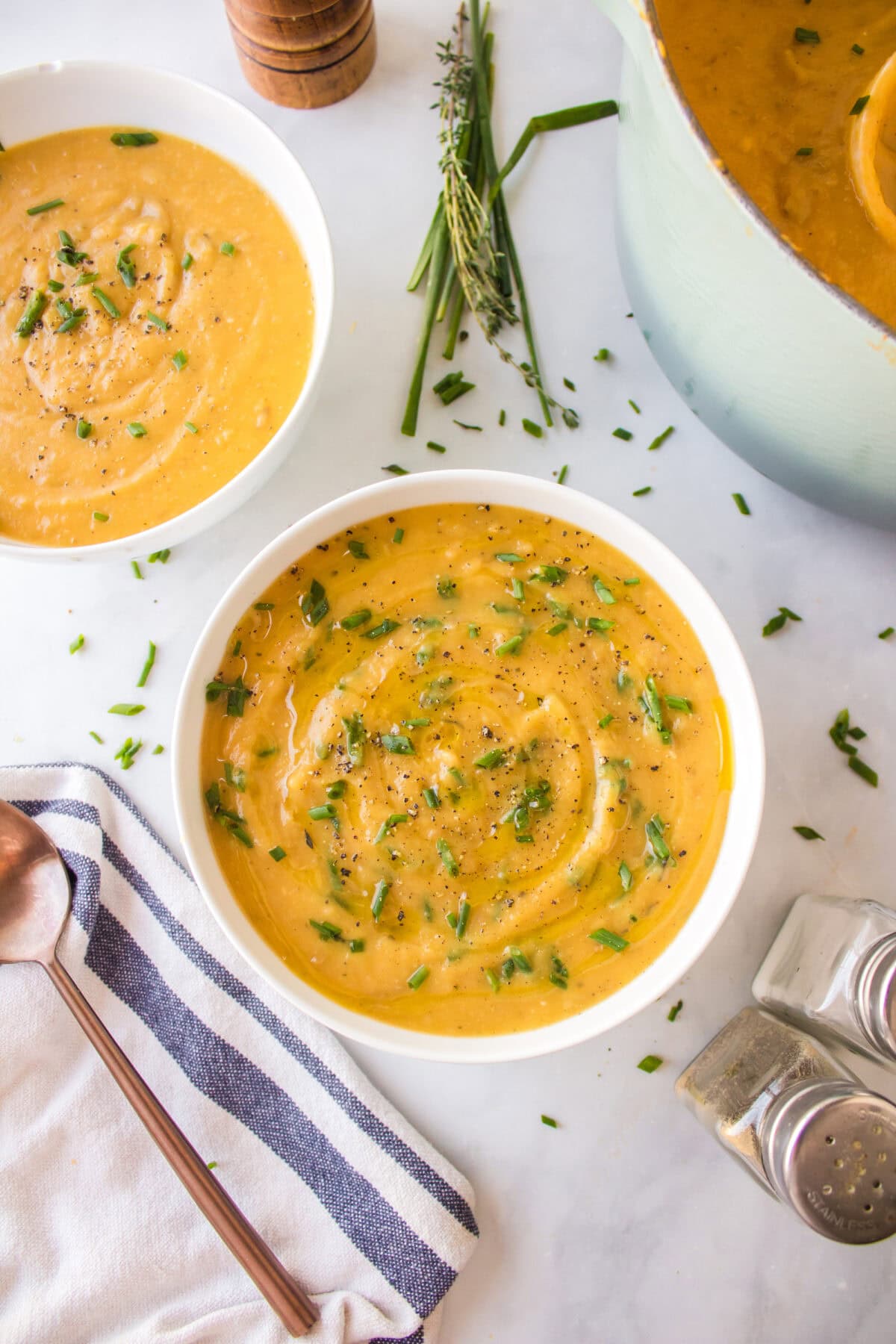 garnishes added to the creamy soup in white soup bowls. 