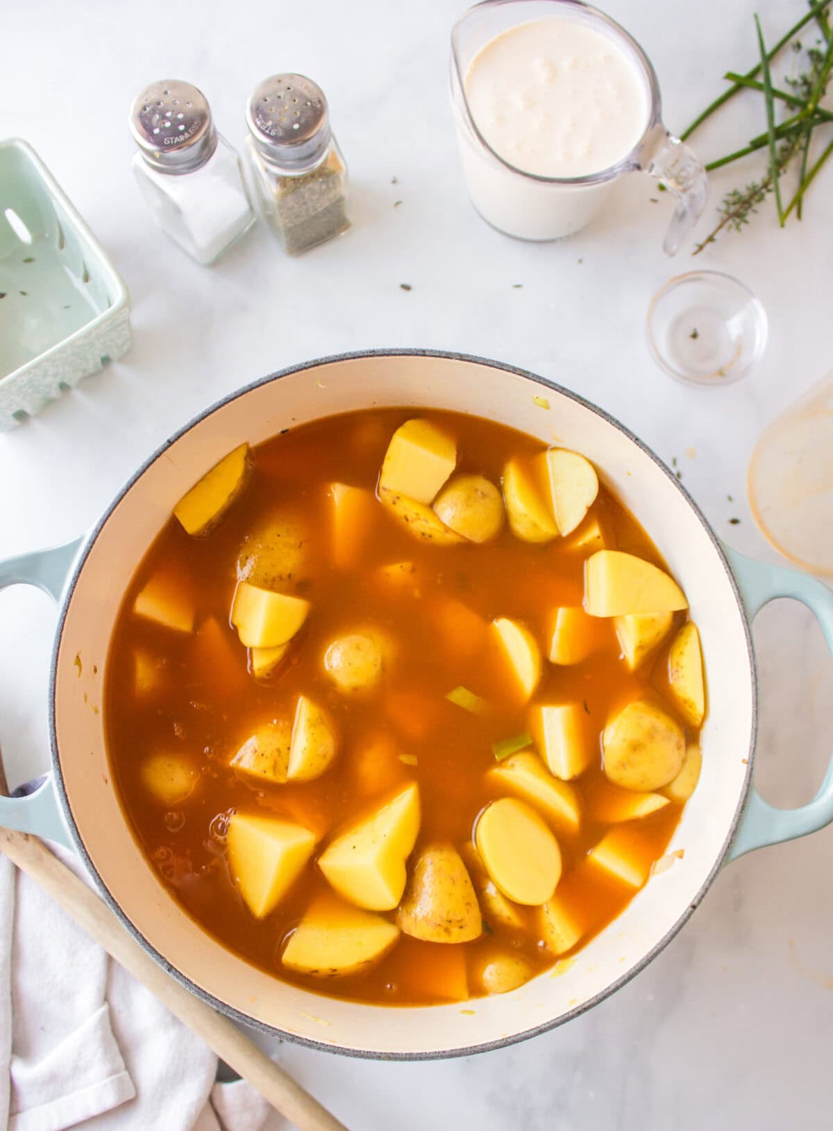 potatoes added to the soup mixture in a dutch oven. 