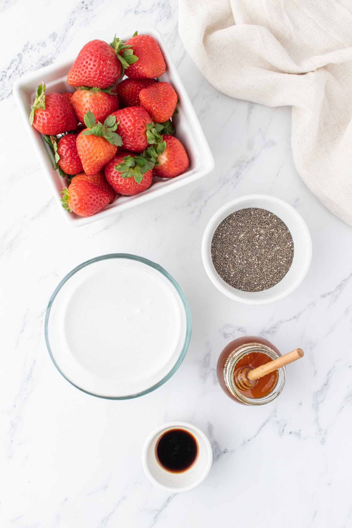 Ingredients for the strawberry chia seed pudding in small bowls. 