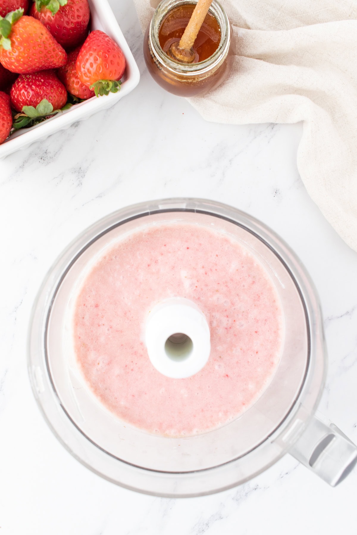 strawberries and coconut milk blended together in a food processor. 