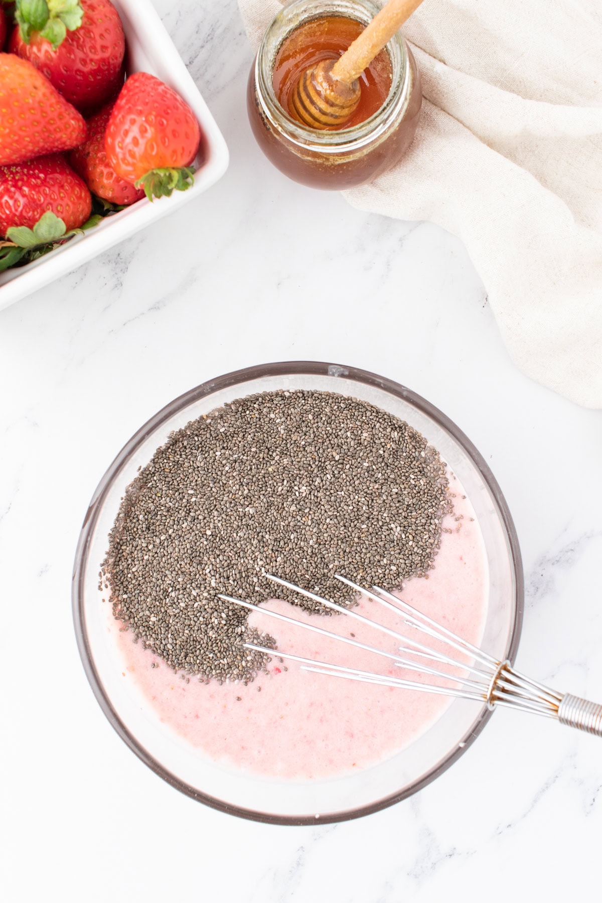 stirring in chia seeds into the strawberry pudding. 