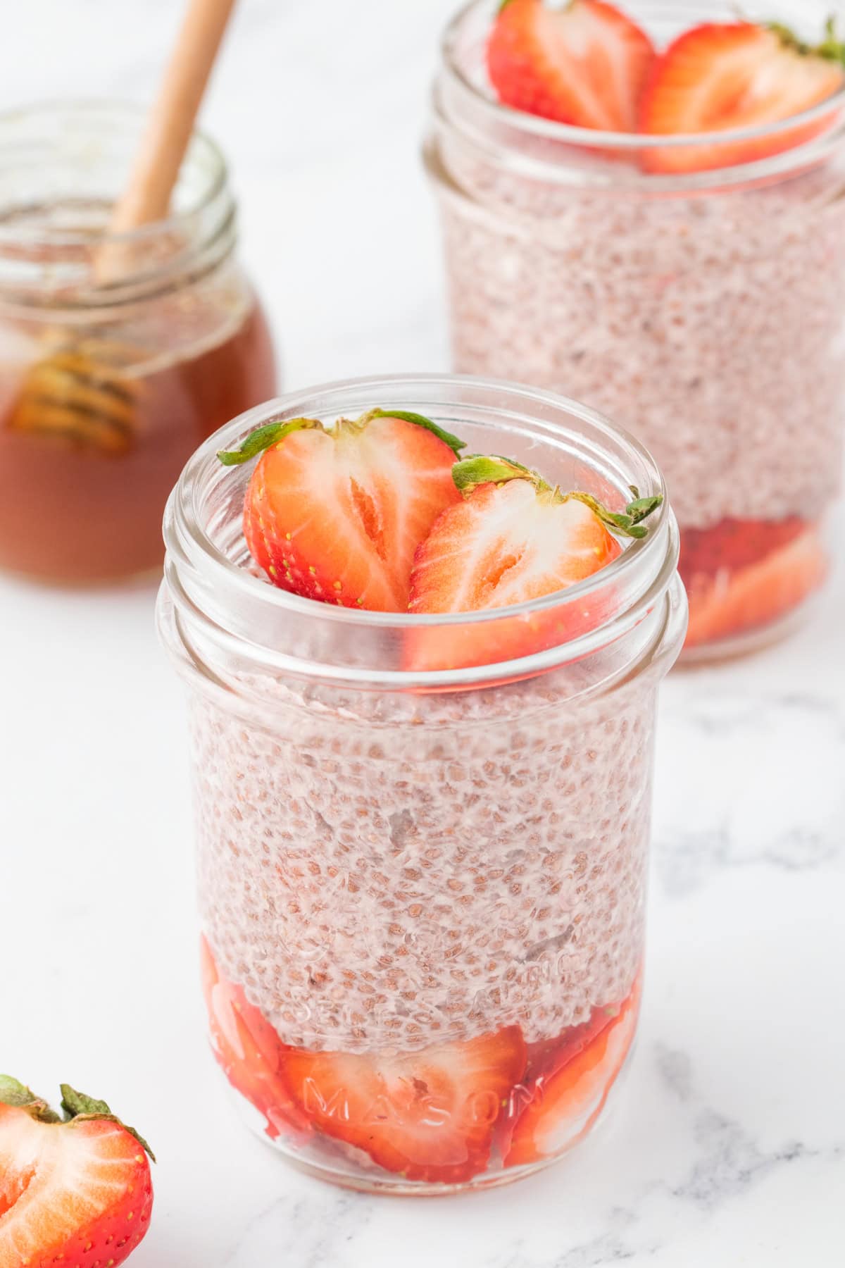 strawberries and plant based chia seed pudding layered in a mason jar like a parfait.